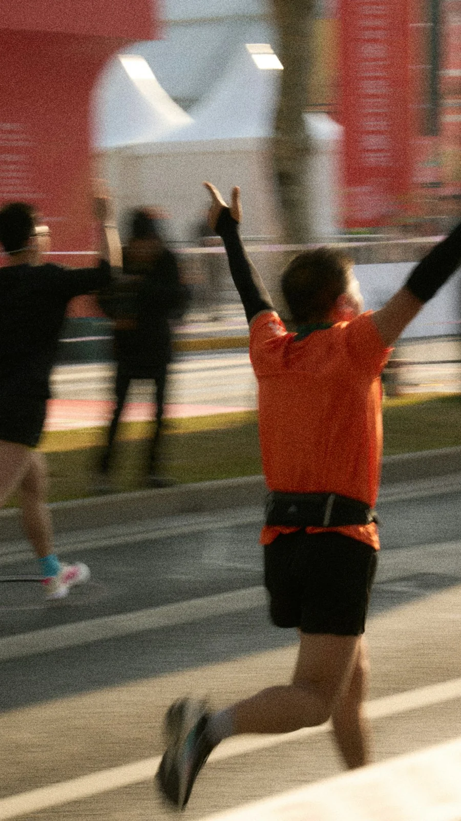Runners with arms raised at the finish of a race